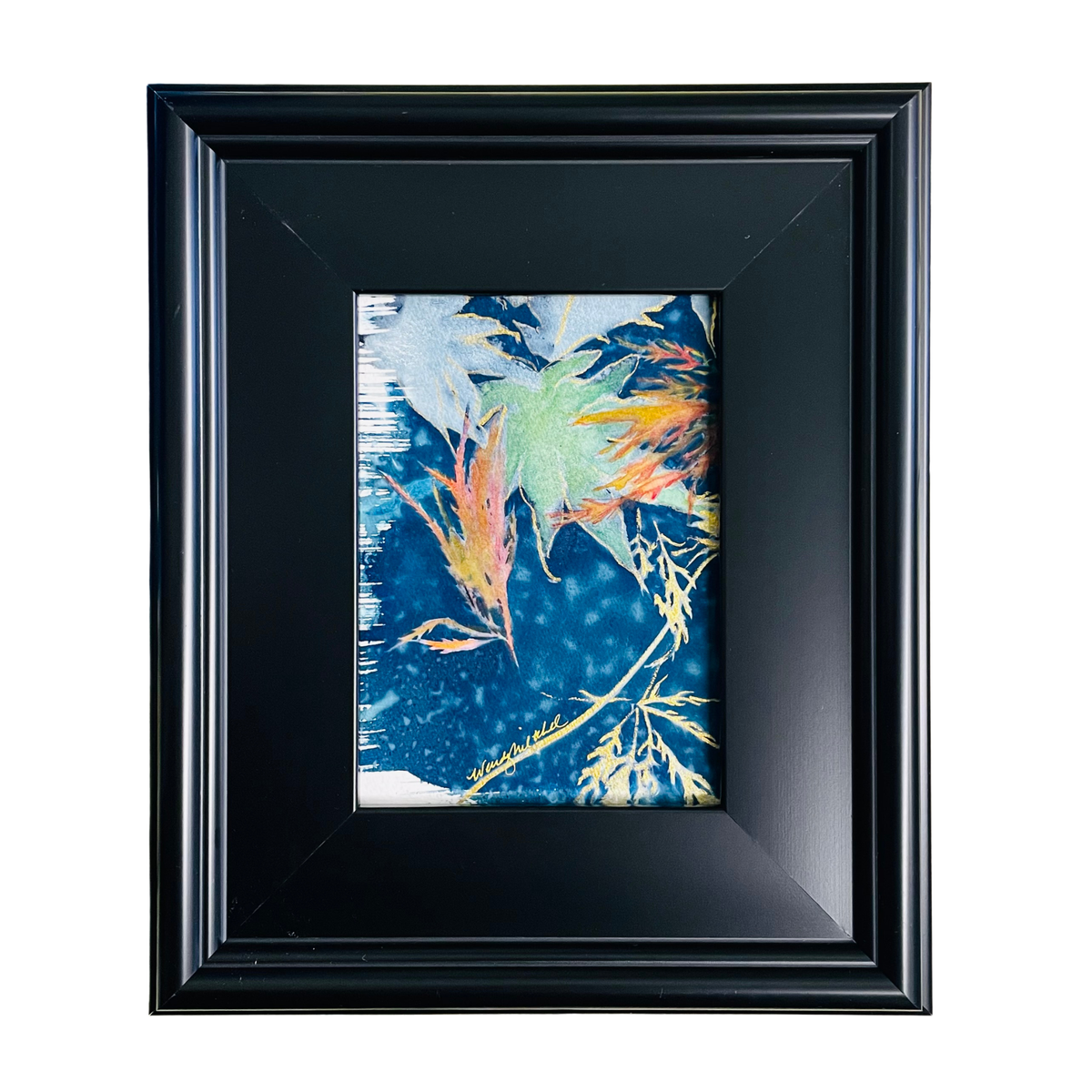 A framed abstract art print featuring blue, green, orange, and yellow brushstrokes, housed in a wide black frame with a black mat border, set against a plain white background.