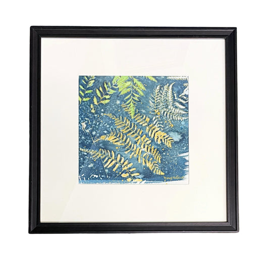 Framed square art print featuring a blue and green fern pattern, set in a white mat and a black frame against a white background.