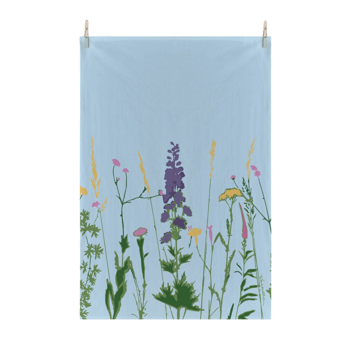 A light blue fabric tea towel with a printed wildflower design, hanging from two wooden clothespins against a solid white background.