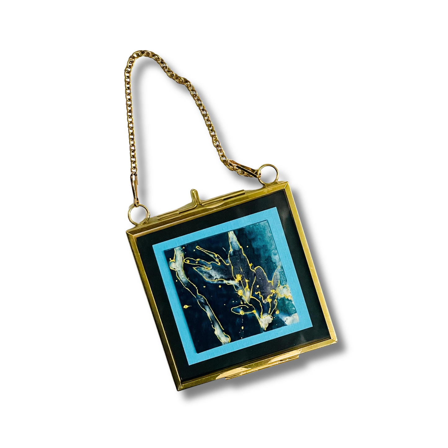 A vintage-style square clutch purse with a gold-tone metal frame, chain strap, and a dark blue abstract art print on the front, set against a plain white background.